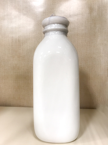A white ceramic milk jug sits on display.