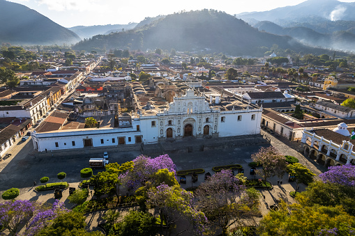 Drone view of the central Plaza and Park in Antigua Guatemala with a view of the San Jose Cathedral ruins during sunrise