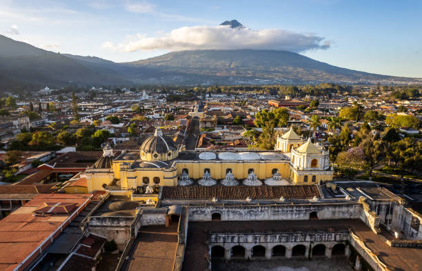 Convent and Church of La Merced in downtown Antigua Guatemala with a view of the Agua Volcano Drone view of the convent and Church of La Merced in downtown Antigua Guatemala with a view of the inactive Agua Volcano on a sunny bright morning agua volcano photos stock pictures, royalty-free photos & images