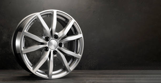 istock new grey alloy wheels on a dark textured black background. car wheel , copy space panorama empty space 1386386534