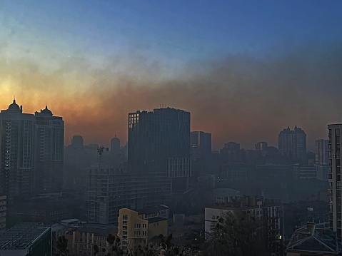 Kiev capital de la ciudad de Ucrania en humo acre después de la explosión en la madrugada, vista a través del vidrio de la ventana. Las luces se apagaron en las casas debido al toque de queda. photo