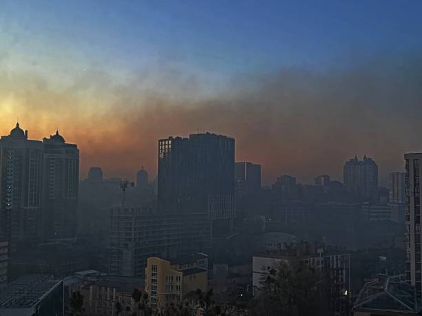 kiev ville capitale de l’ukraine dans la fumée âcre après l’explosion dans le petit matin, vue à travers la vitre de la fenêtre. les lumières ont été éteintes dans les maisons en raison du couvre-feu. - kiev photos et images de collection