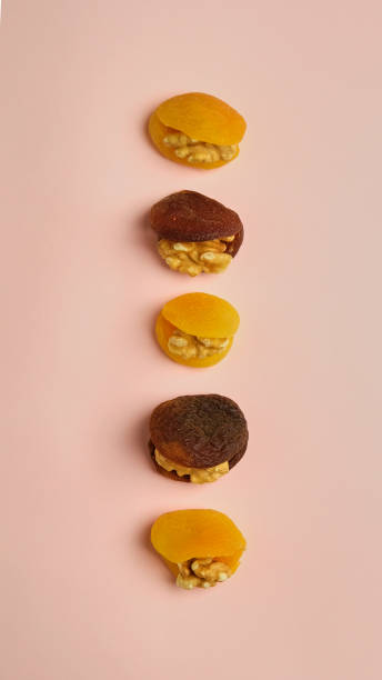istock Dried Apricot, dried apricot and walnut on pink background, top view 1386387929
