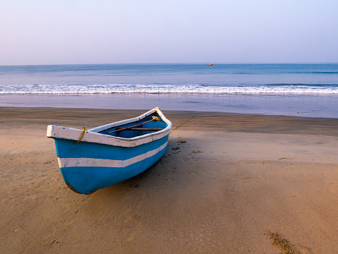Trincomalee, North Western Province, Sri Lanka - March 3rd 2023: Colorful small fiberglass fishing boats pulled up on the tropical beach