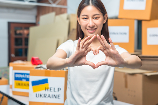 Volunteers preparing food donations for people in need in Ukraine, Humanitarian aid concept.Hands making sign Heart .