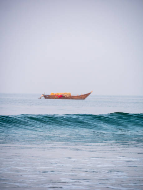 Arabian Sea waves with Empty Fisherman boat in the background. Vertical or portrait orientation