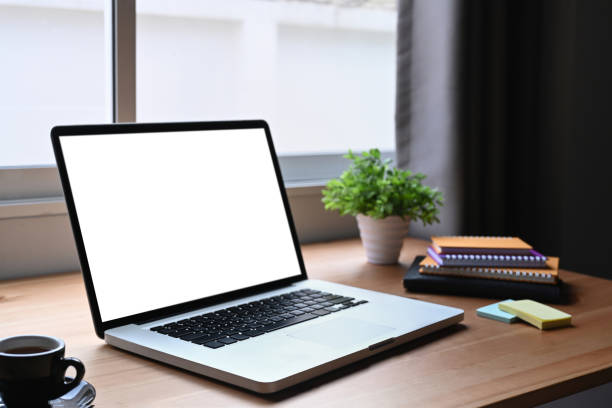 istock Contemporary workplace with laptop computer, notebook, coffee cup and houseplant on wooden table. 1386393078