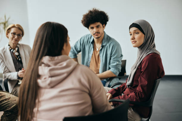 istock Multi-ethnic people having counseling during group therapy meeting at community center. 1386400728