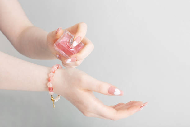 istock female hands with perfume bottle on white background 1386402612
