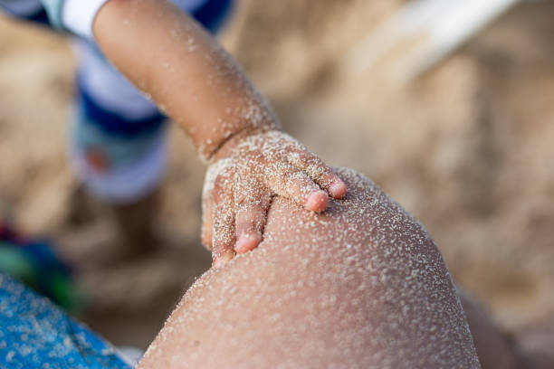 Baby's foot in the sand stock photo