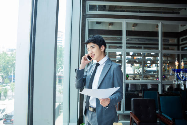 businessman standing in front of glass windows stock photo