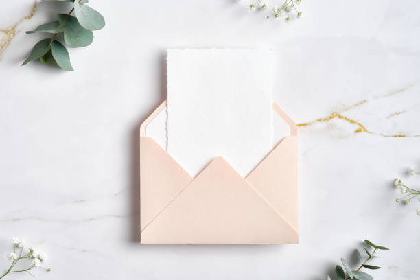 istock Pink envelope with white paper card inside and eucalyptus branches on marble table 1386404902