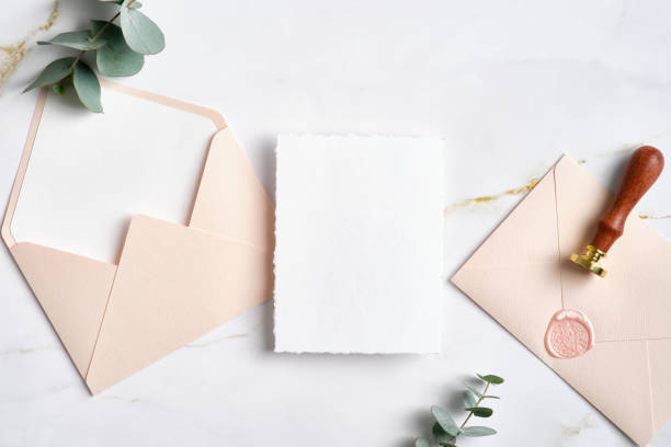istock Blank white invitation card with pink envelopes and eucalyptus leaves. Wedding stationery set. Flat lay, top view, copy space. 1386404905