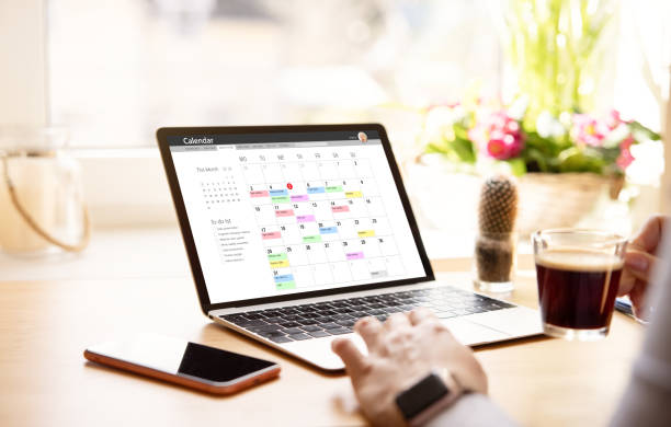 istock Woman looking at calendar on laptop 1386405740