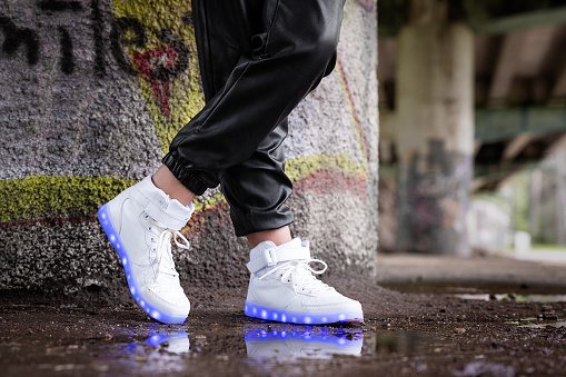 Girl wearing modern shoes with LED lights in soles