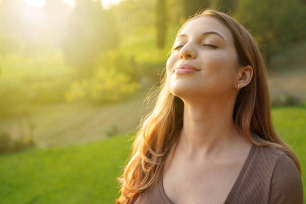 zbliżenie kobieta o zachodzie słońca relaksujące oddychanie świeżym powietrzem - wdychając zdjęcia i obrazy z banku zdjęć