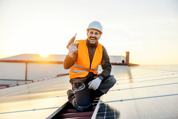 A worker preparing to install solar panels and smiling at the camera. stock photo