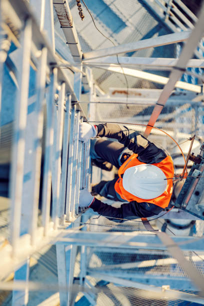 a heavy metal industry worker climbing up the metal construction. - torre de alta imagens e fotografias de stock