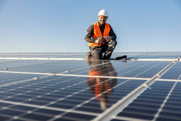 istock A handyman holding electrical screwdriver and preparing to install solar panels on the roof. 1386418344