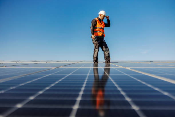 istock A worker walking around roof and checking on screws on solar panels. 1386418422