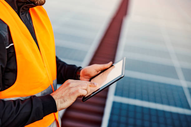 istock Close up of hand holding a tablet and testing solar panels. 1386419690