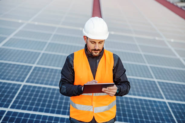 istock Portrait of a focused worker testing solar panels on tablet. 1386419902