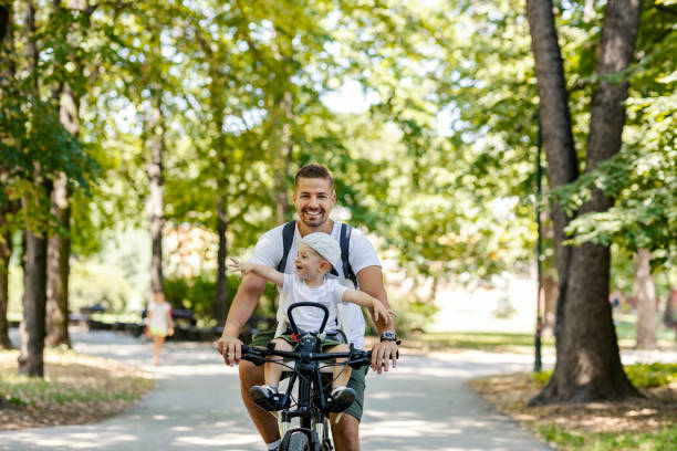 istock Father and son riding a bicycle in nature on earth's day. 1386421709