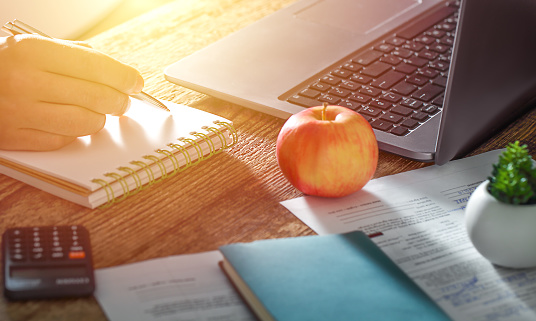 the hand holds a pen and works on calculating the data. The concept of a business office and online training