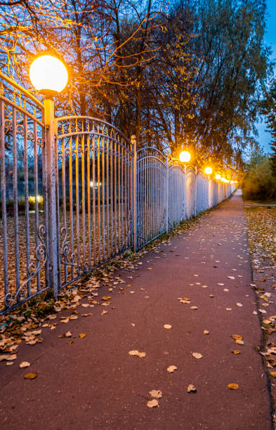 istock sidewalk stretching along the metal fence and lanterns 1386432918