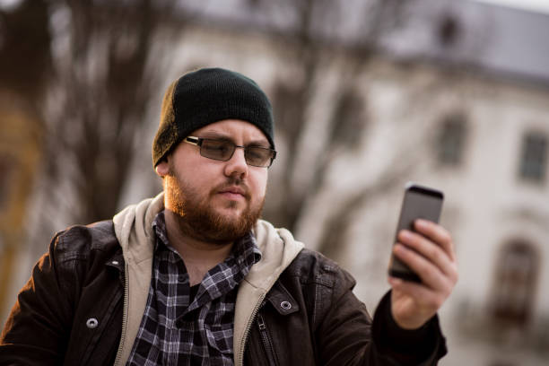 istock Man using phone in the city 1386435830