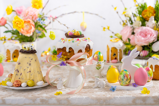 Festive Easter table setting. Easter cake, Easter Eggs, Flower arrangements and home decorations for holiday.