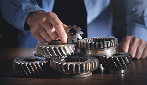 istock Man working with a metal gear wheels. 1386436400