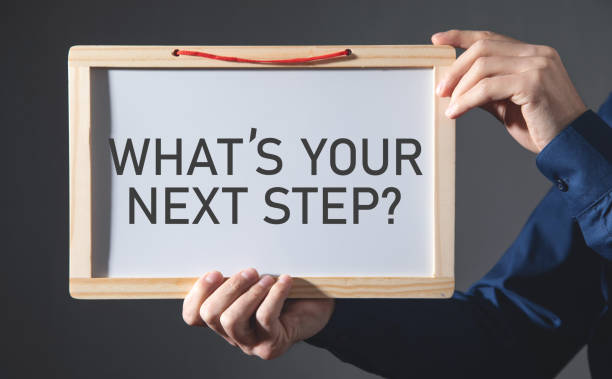 istock Man showing What's Your Next Step? on small whiteboard. 1386436424
