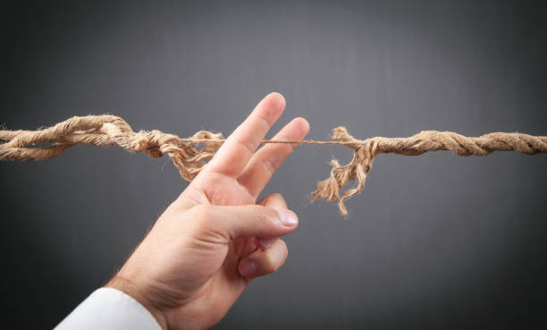 istock Male hand showing frayed rope. Risk 1386436435
