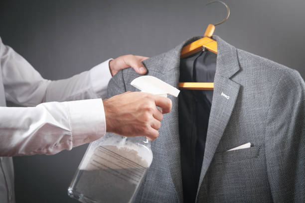 istock Man using cleaning liquid disinfectant spray in suit. 1386436450