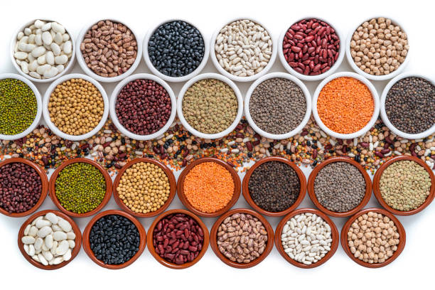 istock Dried legumes assorted in bowls on white including lentils, chickpeas, soybeans and beans 1386445828