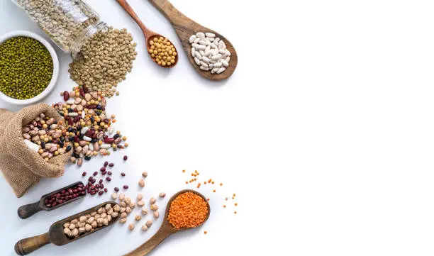 Assorted dried legumes isolated on white background copy space with beans, lentils, soybean and chickpeas