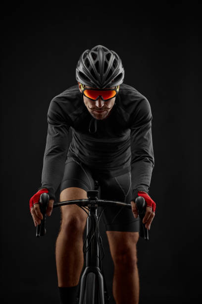 istock male cyclist riding road bicycle on black background 1386445976