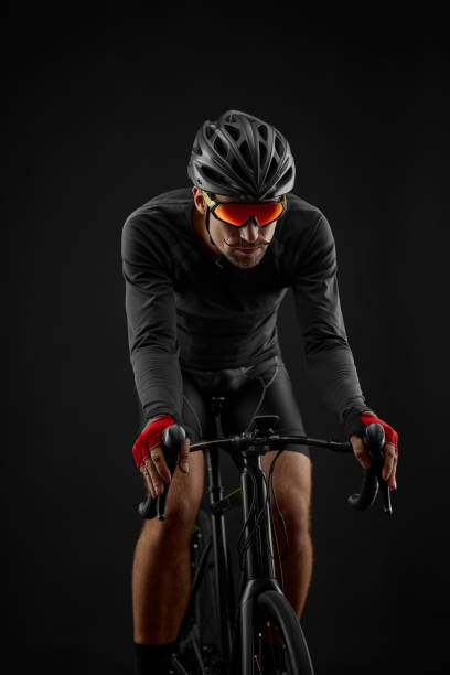 istock male cyclist riding road bicycle on black background 1386445980