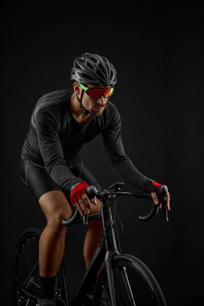 istock male cyclist riding road bicycle on black background 1386445985