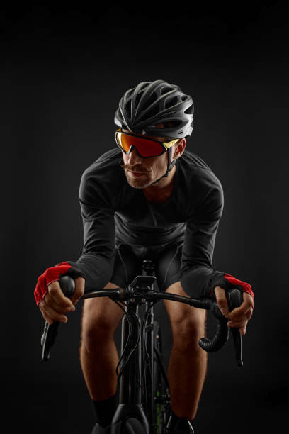 istock male cyclist riding road bicycle on black background 1386446100
