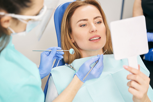 Mujer que se somete a un examen dental en la clínica de estomatología photo