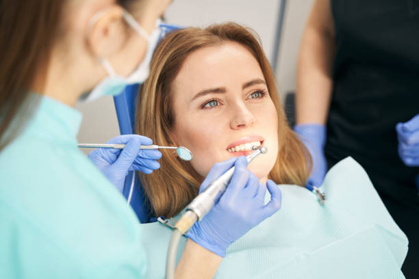 istock Dentist performing teeth treatment with dental device 1386446106
