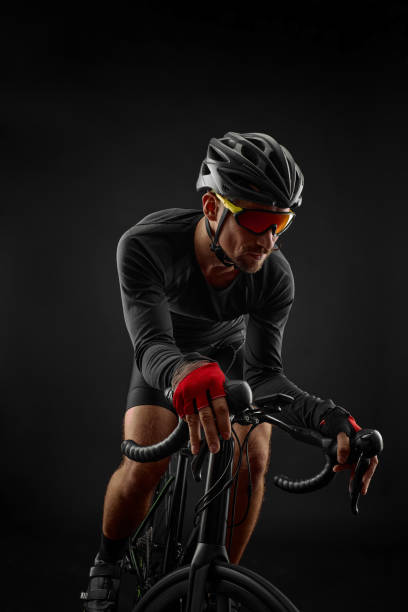 istock male cyclist riding road bicycle on black background 1386446149