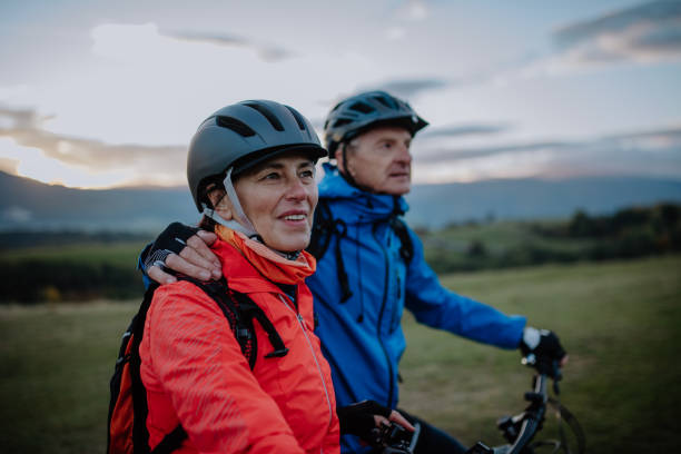 istock Active senior couple riding bikes outdoors in forest in autumn day. 1386446187