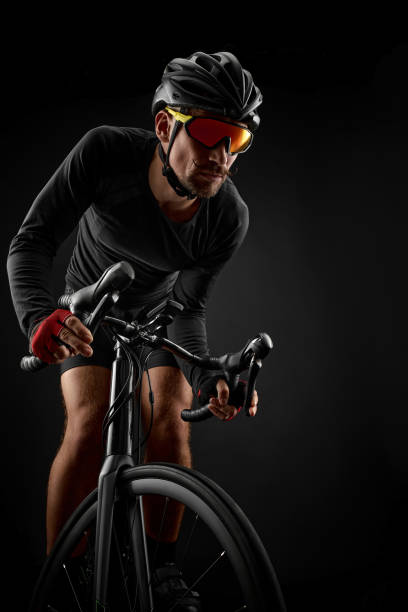 istock male cyclist riding road bicycle on black background 1386446251