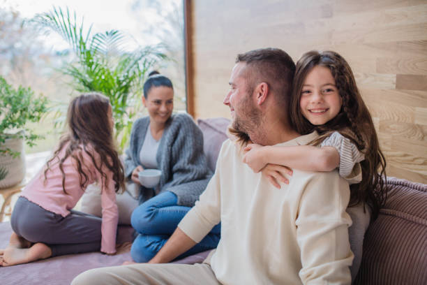 istock Two happy sisters having fun with father nad mother at home 1386446257
