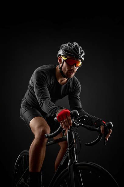 istock male cyclist riding road bicycle on black background 1386446273