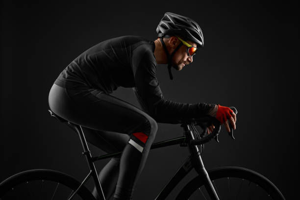 male cyclist riding road bicycle on black background