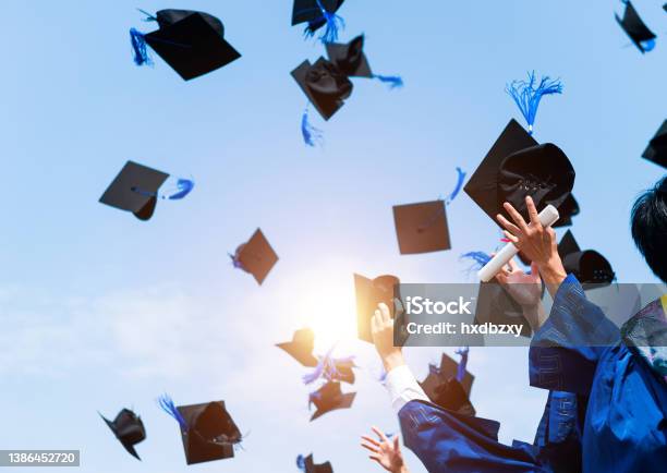 Graduating Students Hands Throwing Graduation Caps In The Air Stock Photo - Download Image Now